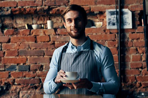 istock male waiter wearing apron coffee cup service lifestyle 2139018086