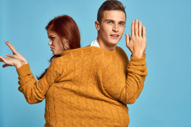 istock couple in yellow sweater posing against blue background cropped view 2139047624