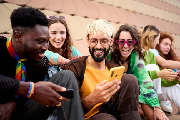 istock Group diverse people enjoying day together outdoors with mobiles in hand. Young multiracial friends. 2139066060