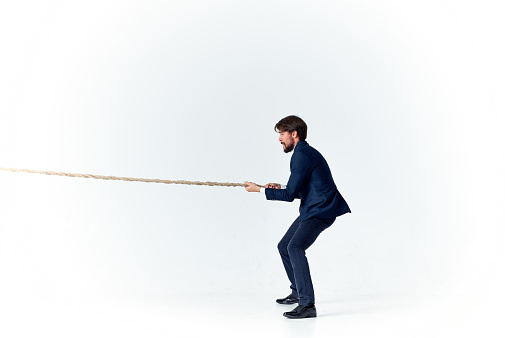 man with rope in hand on light background business finance advertising model. High quality photo