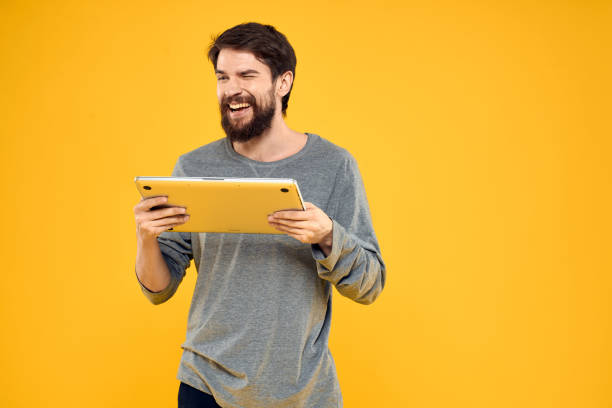 istock man with laptop wireless technology internet lifestyle work yellow isolated background 2139093815