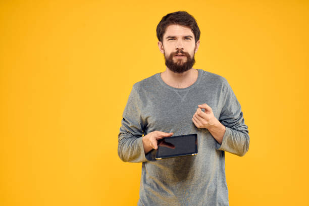istock Man with a tablet in the hands of technology communication professional yellow background 2139103683