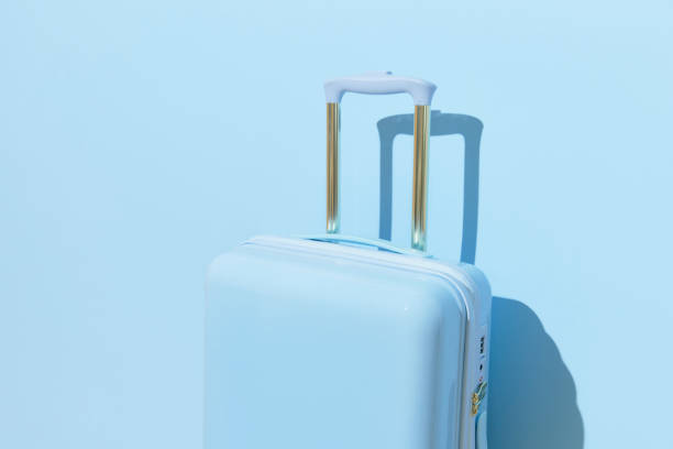 istock Suitcase on a pastel blue background with long deep shadows. Minimal style 2139174468