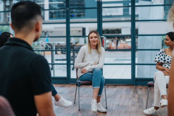 istock Woman talks to peers during group therapy session 2139198976