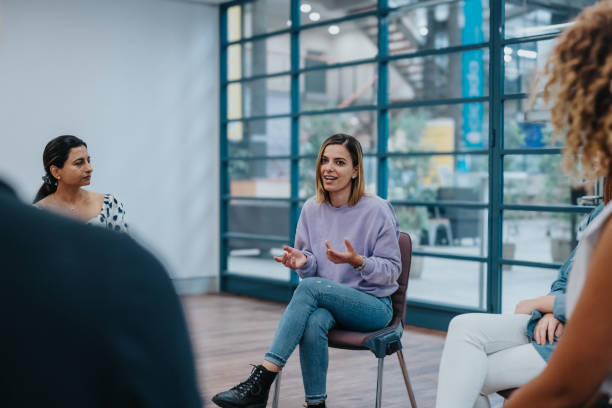istock Hopeful woman speaking in group therapy session 2139198977