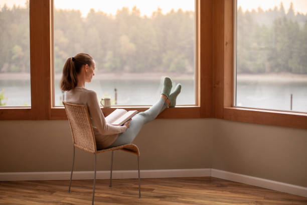 istock Woman reading book and relaxing at home. 2139264427