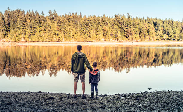 istock Father and son bonding together by the lake. 2139279575