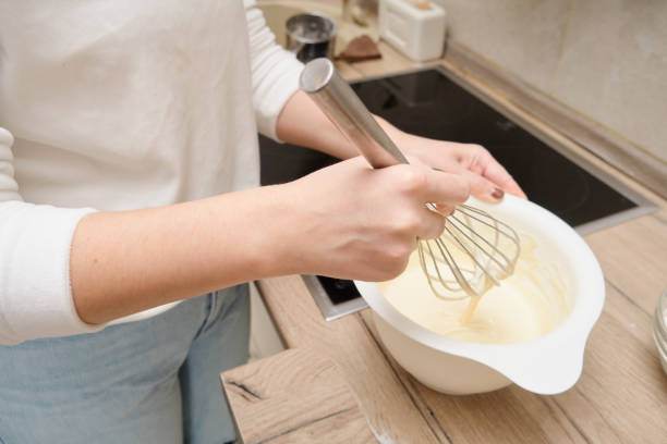 istock Closeup of woman's hands whisking dough in a bowl. 2139292059