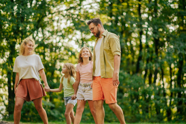 istock A happy family is taking a walk in nature near forest. 2139295337