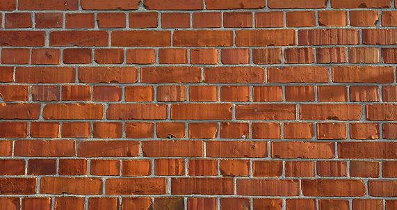 Old red brick wall grunge texture. Old cracked bricks wall with a weathered surface. Brick wall background, copy space for design and text. Vintage brick wall. Empty wall. Brown brickwork texture