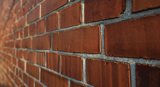 Old red brick wall grunge texture. Old cracked bricks wall with a weathered surface. Brick wall background, copy space for design and text. Vintage brick wall. Empty wall. Brown brickwork texture