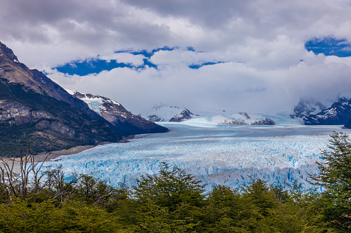 Perito Moreno glacier ice in Patagonia, Argentina Los Glaciers National Park near El Calafate. Bule ice South America mountains patagonian glacier on a sunny day with clouds. Glacier serac falling in lake