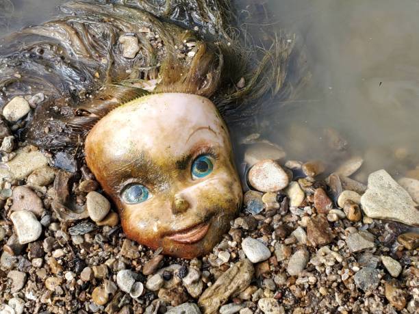 A dirty and grimy, moss covered, doll head found at Post Oak Creek in Sherman, Texas. Sherman is in Grayson County.