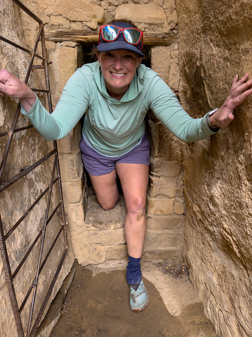 Woman Pops Out of Narrow Walkway through Cliff Dwelling in Mesa Verde