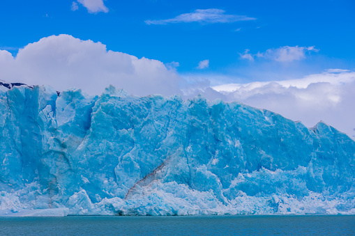 Perito Moreno glacier ice in Patagonia, Argentina Los Glaciers National Park near El Calafate. Bule ice South America mountains patagonian glacier on a sunny day with clouds. Glacier serac falling in lake