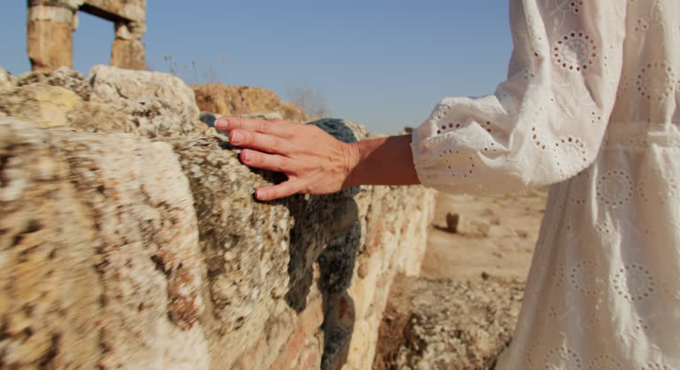 Woman hand touch of ruin ruins in ancient greek city Hierapolis in Pamukkale