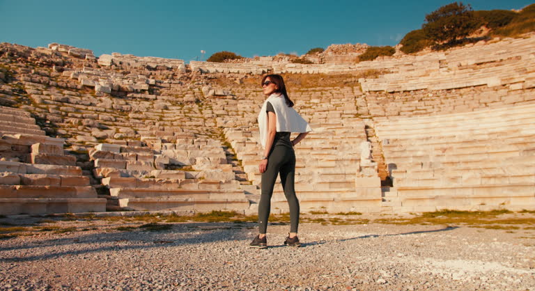 Woman watching the ruins of Antique Theater in ancient city Knidos