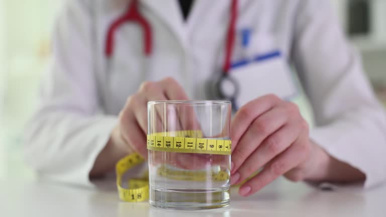 Doctor nutritionist measuring glass of water with centimeter tape closeup 4k movie