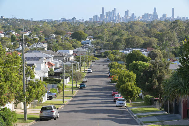 Residential houses street against Brisbane City skyline in Queensland Australia stock photo