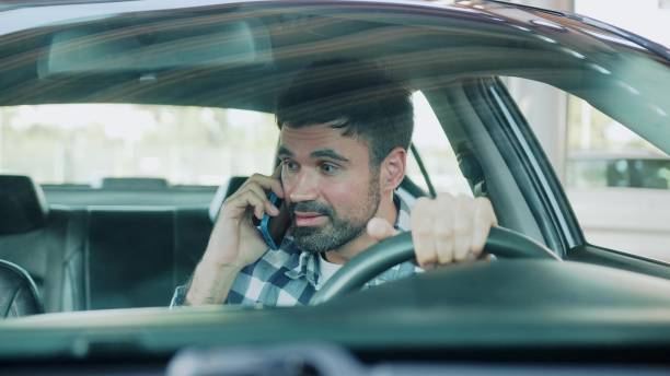 istock Angry guy talking on the smartphone, sitting in the car. Slow motion 2139440810