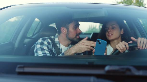istock Young couple arguing while driving a car, using navigation on phone Slow motion 2139440825