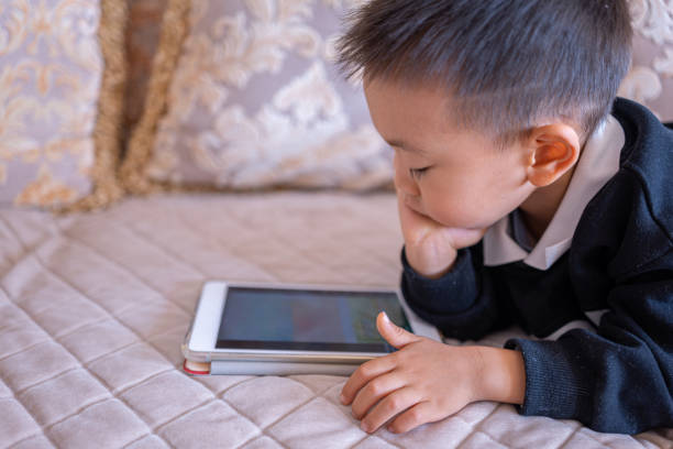 istock The cute little boy is watching an iPad 2139518117