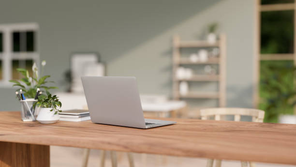 istock A back view of a laptop computer on a wooden table in a contemporary bright room. 2139584598