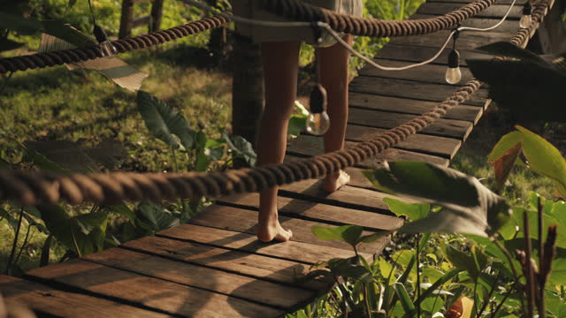 Barefoot woman Walking on a wooden bridge
