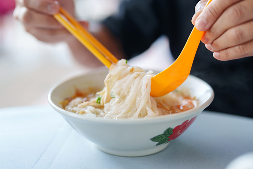 Adult women eating vegetarian udon noodle