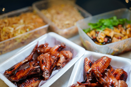 Various options of delivery takeout food are neatly arranged in plastic containers on a table, all set for a satisfying meal.