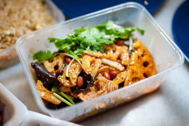 Various options of delivery takeout food are neatly arranged in plastic containers on a table, all set for a satisfying meal.