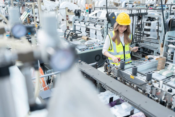istock Large industrial plants and modern computerized machines are producing automotive export products and robots are operated by female Asian engineers wearing hard hats and holding laptops. 2139755630