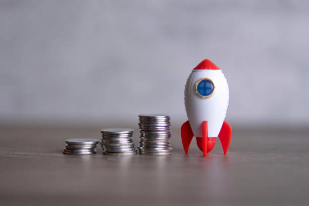 istock Closeup image of rocket spaceship and coins. 2139792838