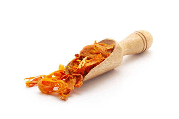 Front view of a wooden scoop filled with Organic Mace (Myristica fragrans) or javitri. Isolated on a white background.