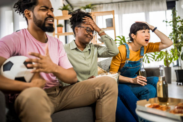 istock Multiracial group of friends watching soccer game, cheering and drinking beer. 2139796856