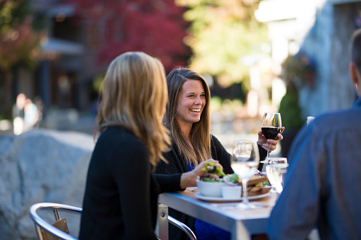 Friends enjoy meal at outdoor cafe in summer