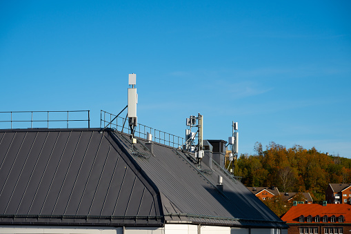 Mobile phone antennae on the top of a roof.