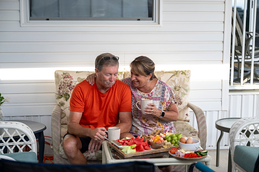 Mature couple enjoy healthy lunch on patio