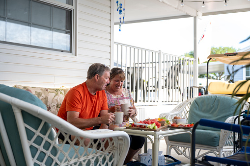 Mature couple enjoy healthy lunch on patio of mobile home