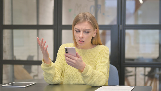 Casual Creative Woman Shocked by Loss on Phone