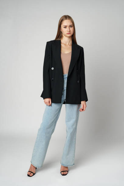 istock Young Woman Wearing Black Jacket and Jeans posing on gray background studio shot . 2139949687