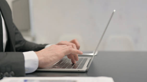istock Side View of Businessman Typing on Laptop 2139960873