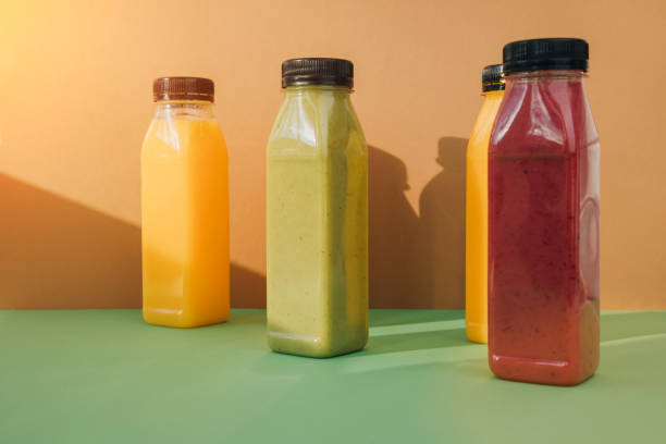 istock Fruit and vegetable smoothies in transparent plastic bottles. Red, green, orange smoothies on a brown-green background 2139971508