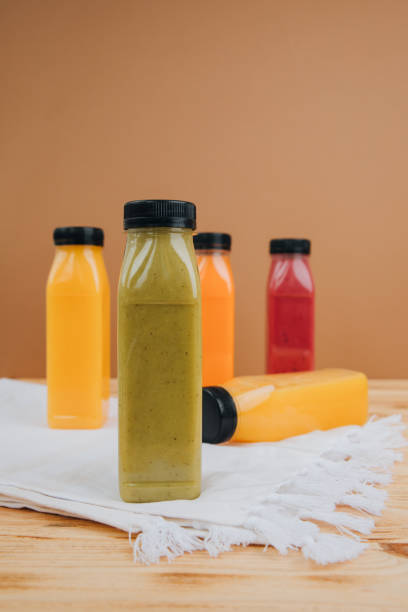istock Fruit and vegetable smoothies in transparent plastic bottles. Green, red, orange smoothies on a brown and wooden background 2139971534