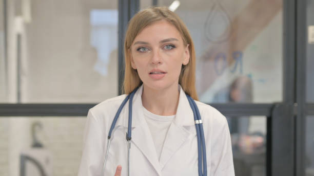 istock Talking Blonde Female Doctor Doing Video Chat 2140005043