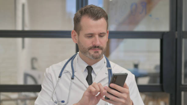 istock Portrait of Middle Aged Doctor Using Smartphone 2140024741