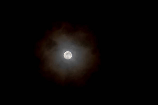 full moon is the main focus of this image. The dark background emphasizes the brightness of the moon, creating a sense of awe and wonder. The moon's round shape