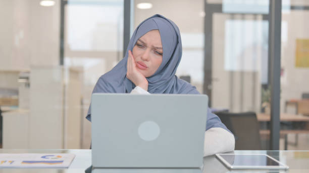 istock Arab Woman with Toothache Working on Laptop in Office 2140058357