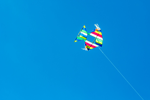 Minimalist image of a unique colored kite in a perfect blue sky during the Festival de la cometa (English : kite festival) in Jerico, Antioquia, Colombia.