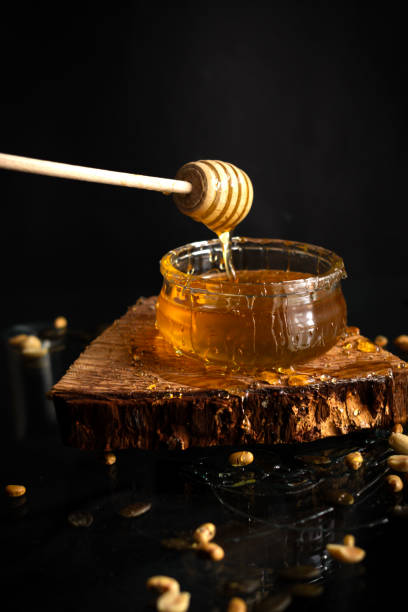 istock Fresh honey in a glass jar on a black background. Deliciously 2140134721